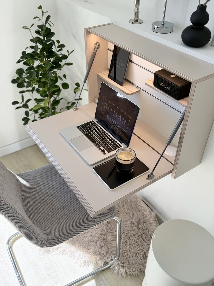 Bureau mural rabattable en bois clair ouvert avec un ordinateur posé